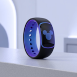 A black and blue Disney-themed smart wristband with a glowing Mickey Mouse icon, placed on a modern white surface.